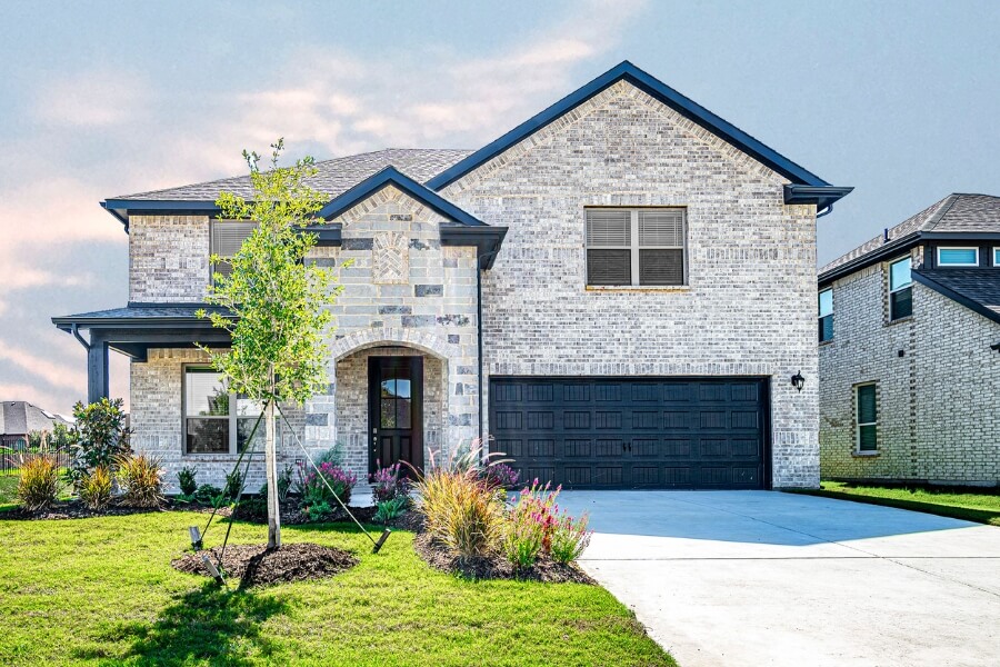 New two-story suburban home with stone facade, manicured lawn, and attached garage.