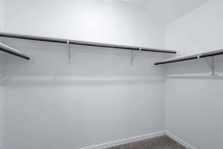 An empty closet with shelves and a carpeted floor.