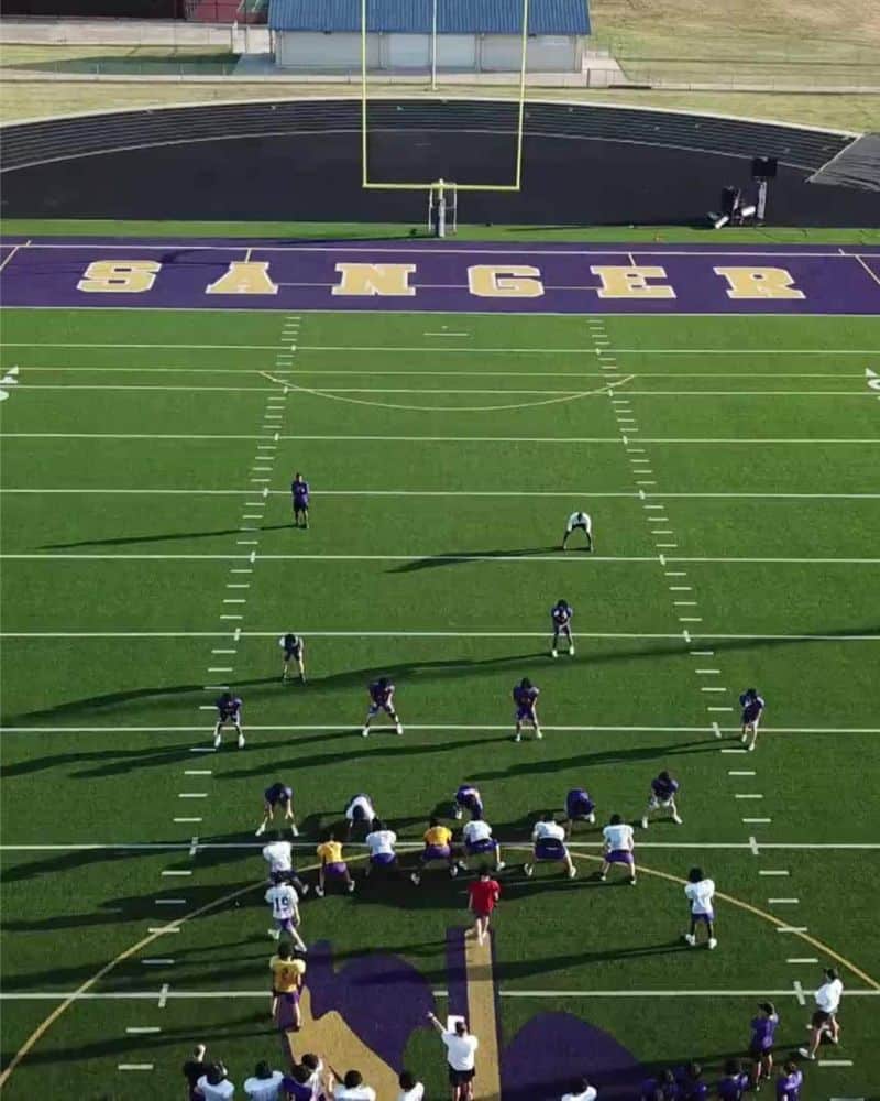 Football practice session on a field with "sanger" printed in the end zone.