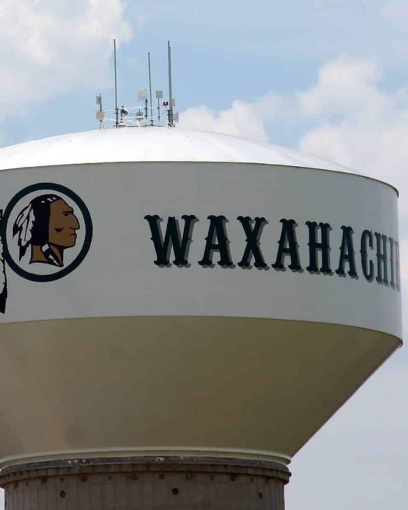 Water tower with "waxahachie" text and a native american-inspired logo.