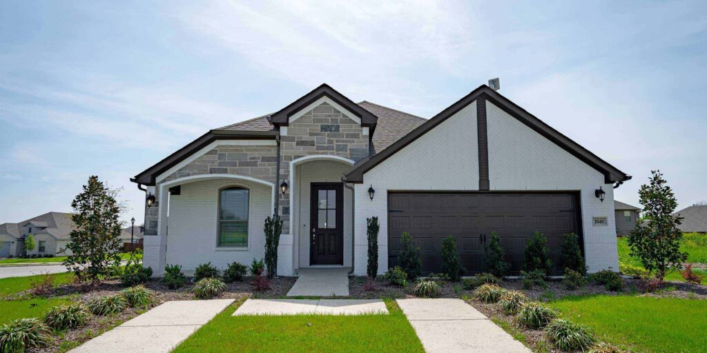 New single-story suburban home with a stone and siding facade and an attached garage.